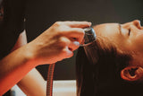 closeup photo of Japanese head spa in Chattanooga, women relaxing with eyes closed while esthetician rinses scalp