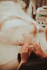 Woman receiving relaxing facial at spa from an esthetician