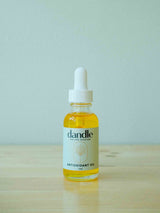 Bright orange Dandle Antioxidant Oil in  glass bottle with white dropper. Organic face oil serum.