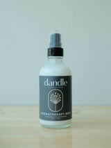 Dandle Lavender & Frankincense Aromatherapy Mist in glass bottle sitting on wood surface. Organic air freshener made with essential oils. Sulfate free
