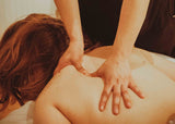 female laying face down on table with massage therapist doing trigger point therapy on shoulder in Chattanooga, TN spa 