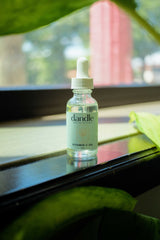 Glass bottle of Dandle Organic Vitamin C face oil serum sitting on a window sill in Chattanooga, TN small business