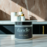 Dandle bath salt jar on a marble surface with a blurred background. Enjoy a peaceful soak in a detoxifying bath with our organic bath salts
