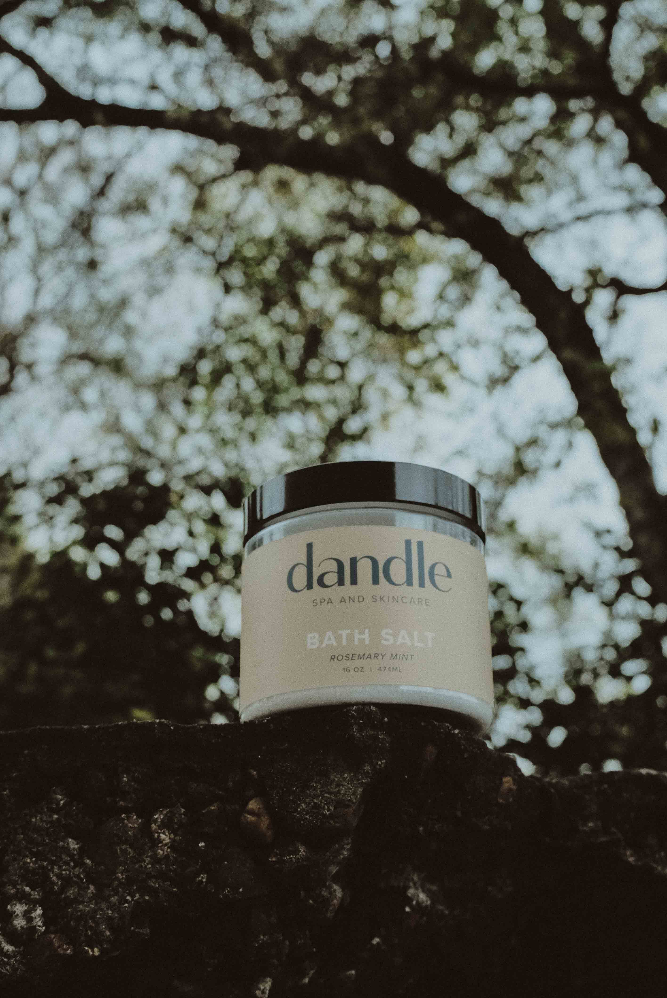 Jar of dandle bath salts on a stone surface with a blurred natural background. Bath salts made with pure essential oils. Locally made in Chattanooga, TN 