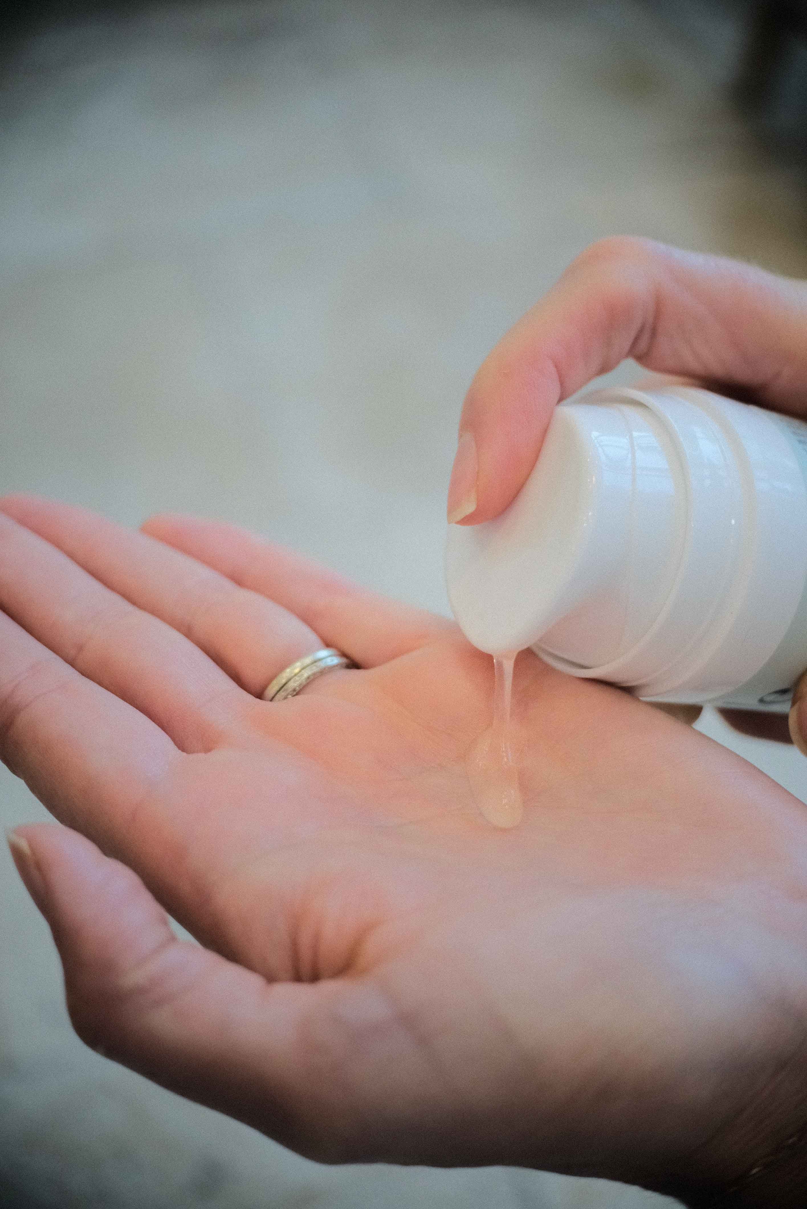 Pink gel face wash being pumped into hand. Best organic gel cleanser for oily skin.