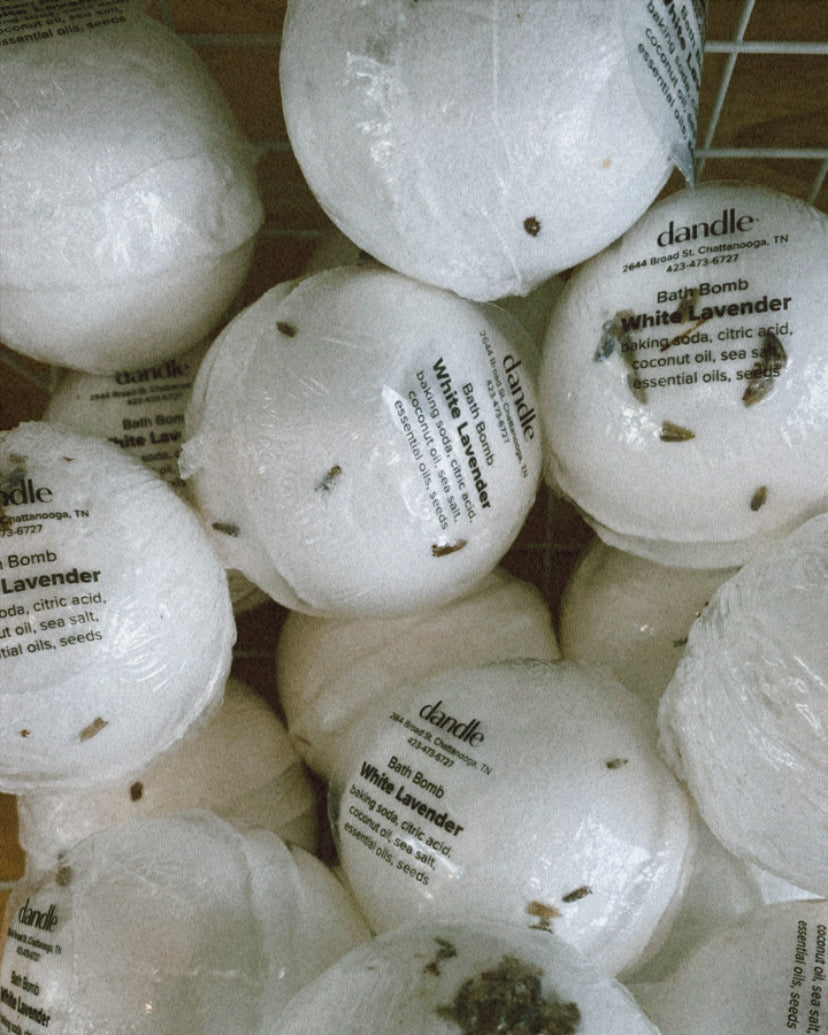 White bath bombs with labels on a tiled surface