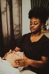 Person receiving a facial massage from another person in a calm setting.