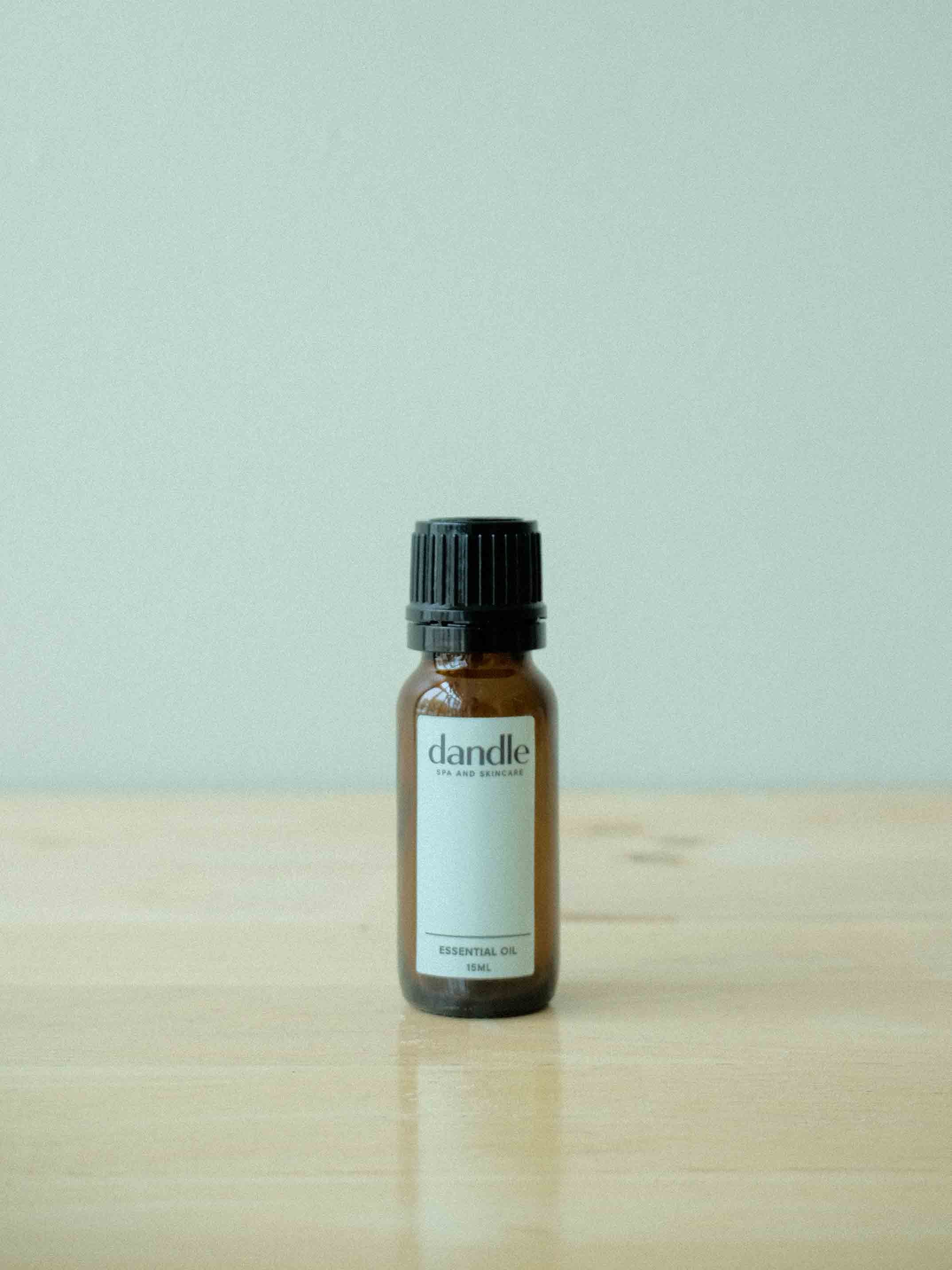 Pure grade Essential Oil Blend in glass bottle sitting on wood surface. Therapeutic essential oil blends to help with headaches, menstrual cramps, congestion, sleep, stress, and immunity.