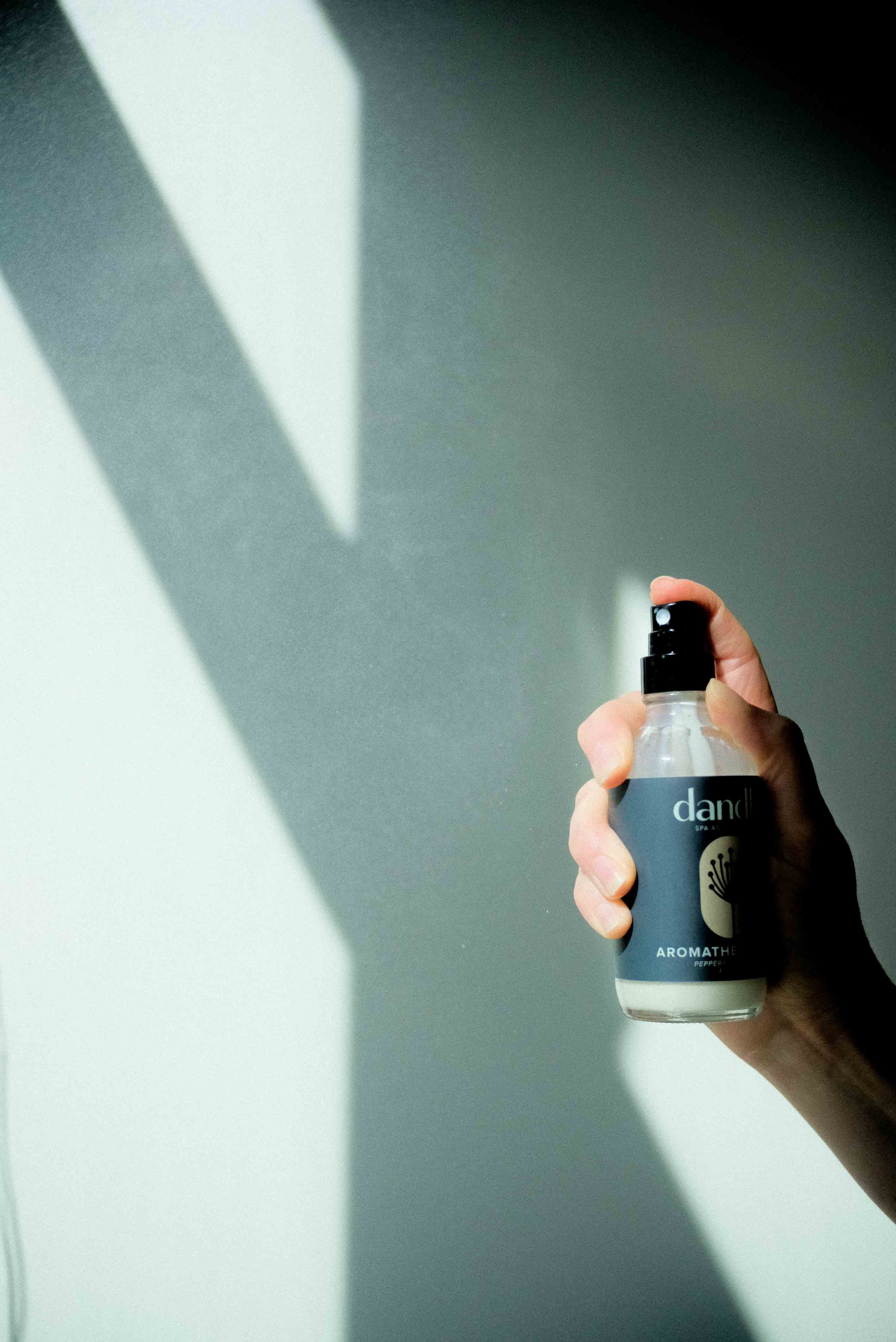 Dandle organic body spray bottle being held and sprayed. Clean air freshener. paraben-free purfume