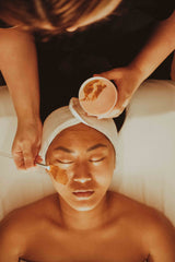 Person receiving a facial treatment with a skincare product.